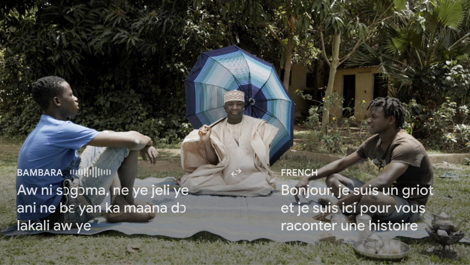 Un griot raconte une histoire à deux jeunes hommes ; sous-titres en bambara et en français.